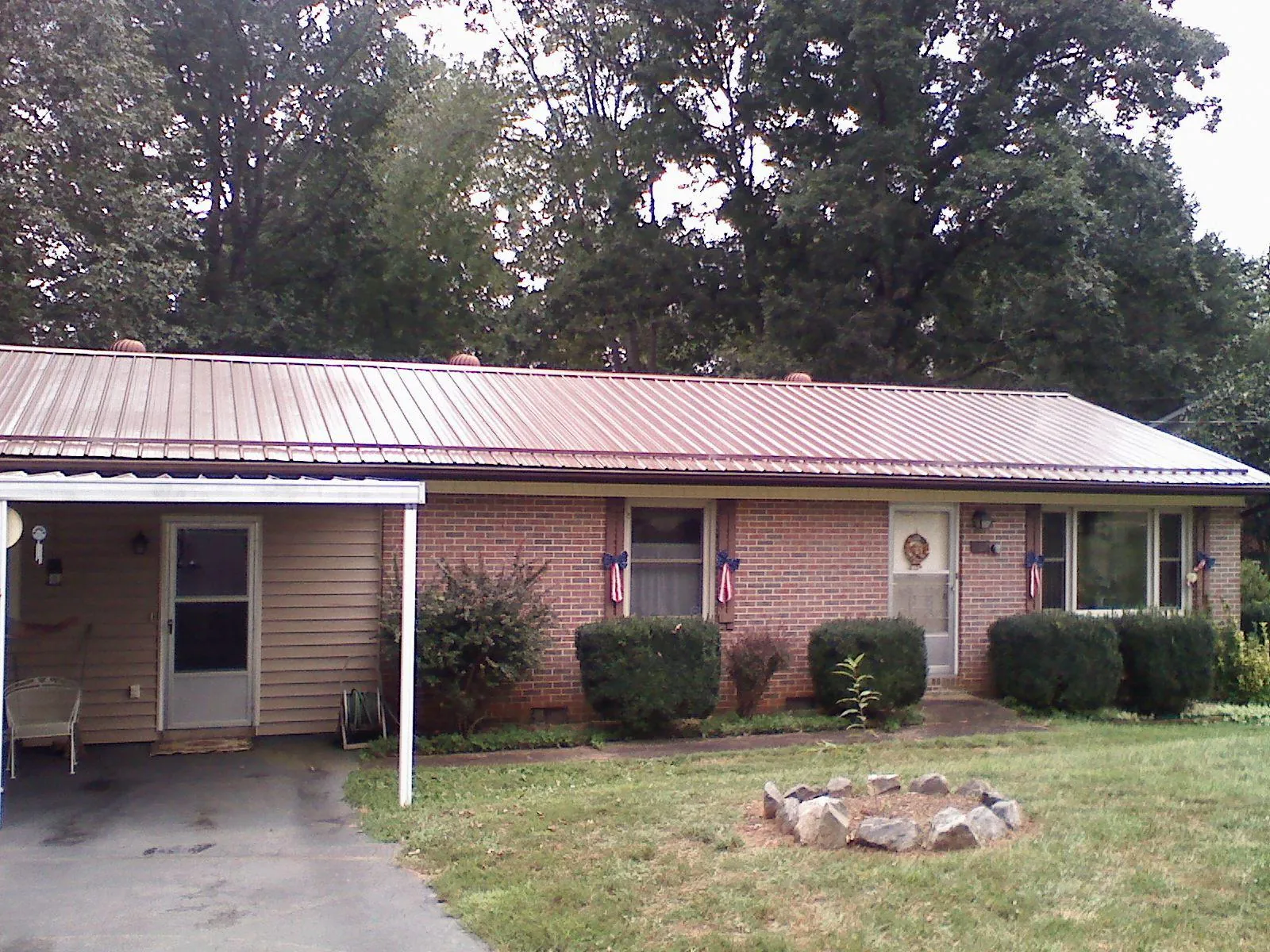 Bronze metal roof and carport on a brick ranch home — Roof Repair work by our crew in Dayton